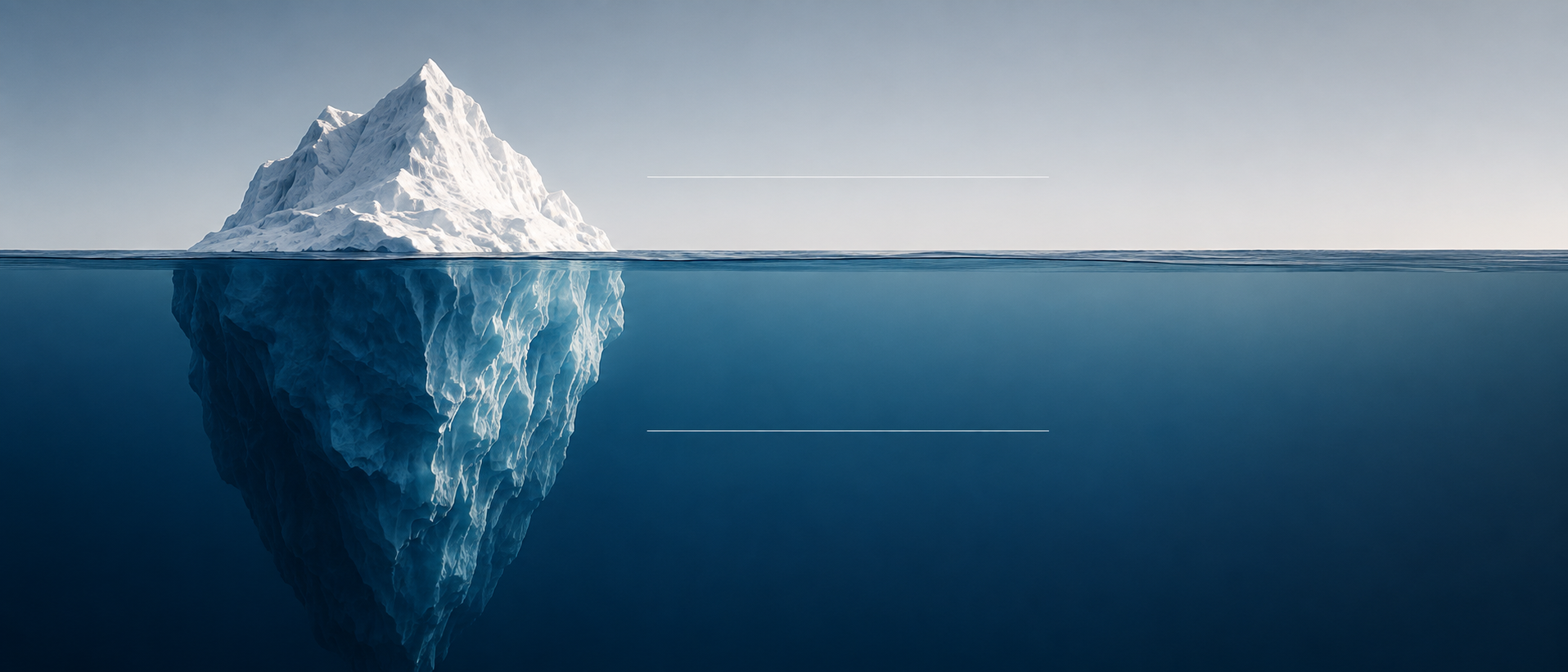 Iceberg showing a small visible peak above water and a much larger structure below the surface.